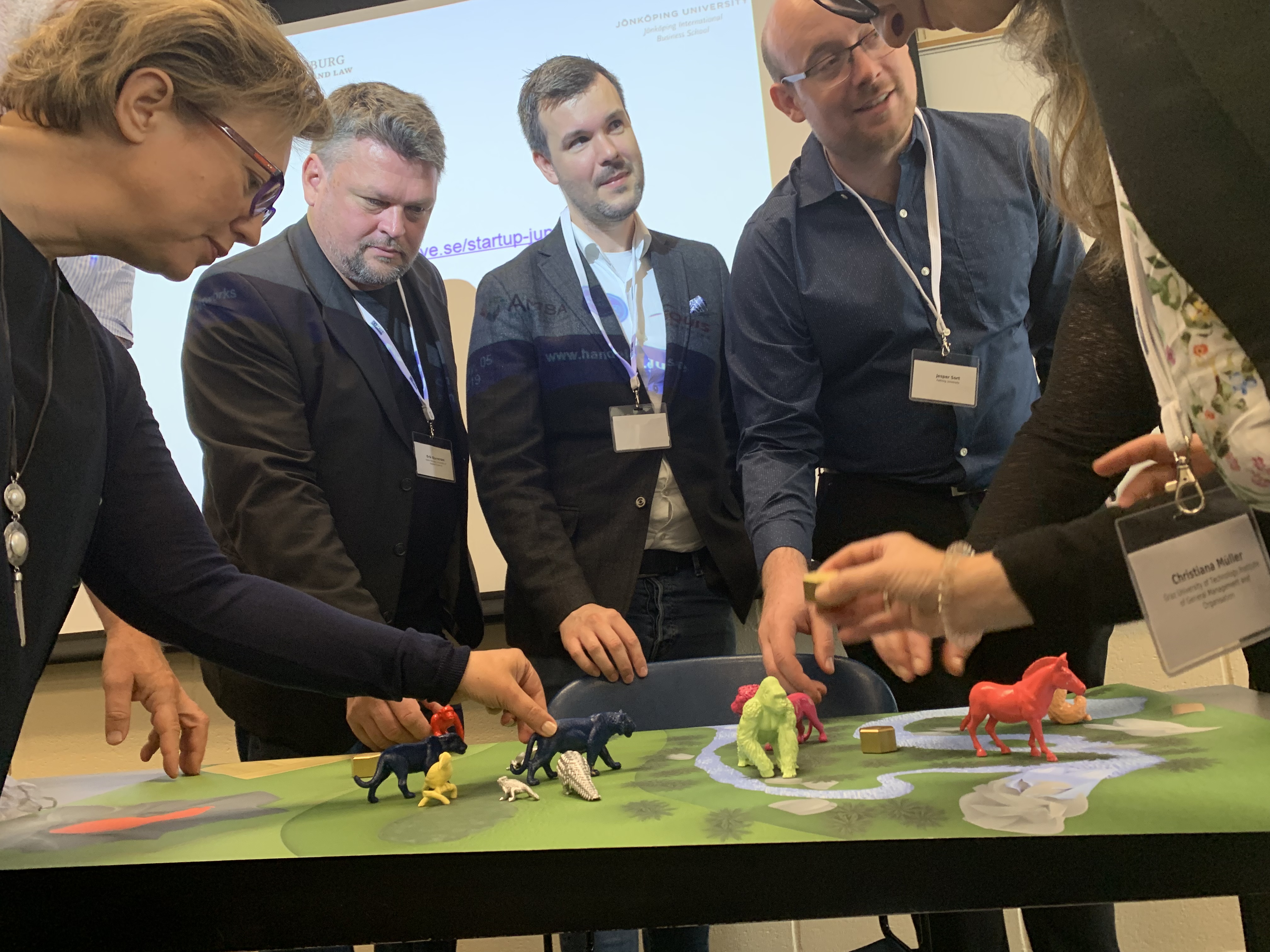 Professionals in a workshop setting collaborating around a tabletop model